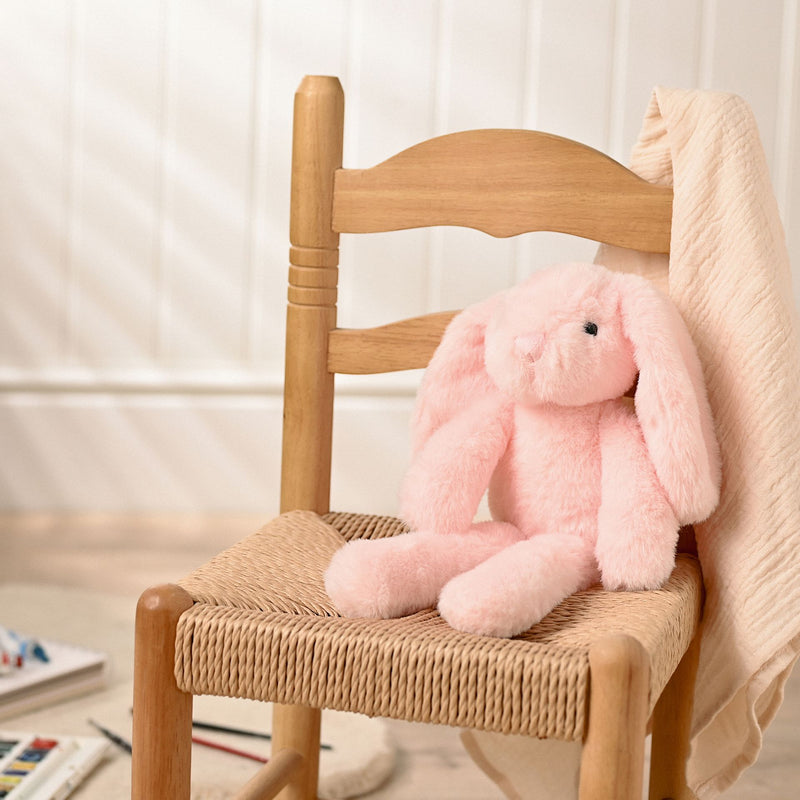 Katie the plush long leg light pink bunny soft toy 35cm, lifestyle shot — sitting on a chair