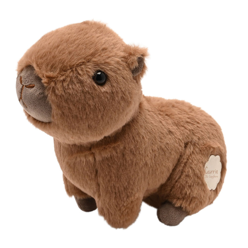 Carrie the Capybara plush soft toy 24cm, three-quarter view showing broad muzzle and shiny dark eyes, Carrie the Capybara badge visible on side, white background