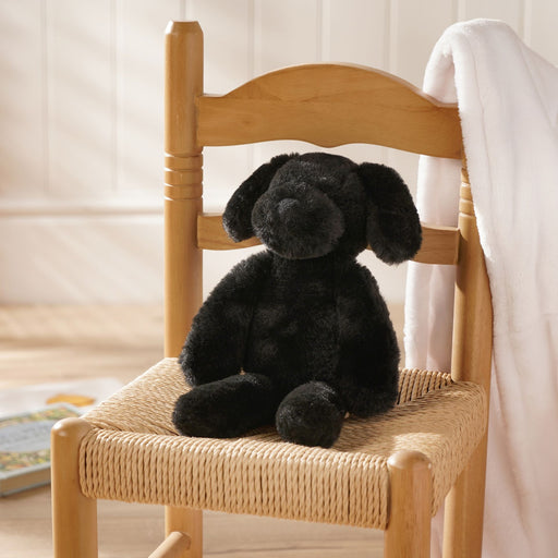 Monty the plush long leg black puppy soft toy 30cm, lifestyle shot — sitting on a chair