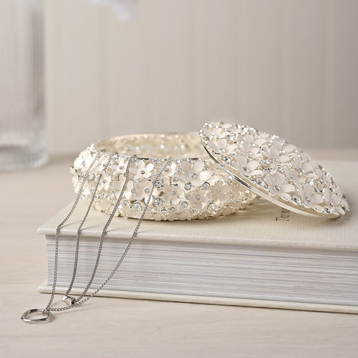 Sophia Classic Daisy trinket box on a cream book with a silver necklace draped alongside, lifestyle shot