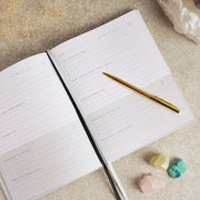 Serenity 5 Minute Journal open to daily journaling page, lifestyle shot with pen