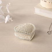 Sophia heart trinket box closed on dressing table with white flowers and necklace, lifestyle shot showing silver-tone finish