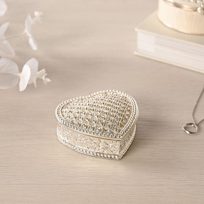 Sophia heart trinket box closed on dressing table with white flowers and necklace, lifestyle shot showing silver-tone finish