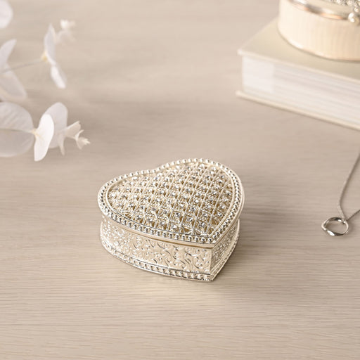 Sophia heart trinket box closed on dressing table with white flowers and necklace, lifestyle shot showing silver-tone finish