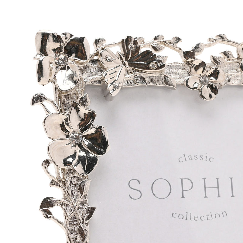 Close-up of Sophia floral butterfly nickel-plated photo frame corner showing flower, leaf and butterfly detail with crystal-effect stone centres, white background