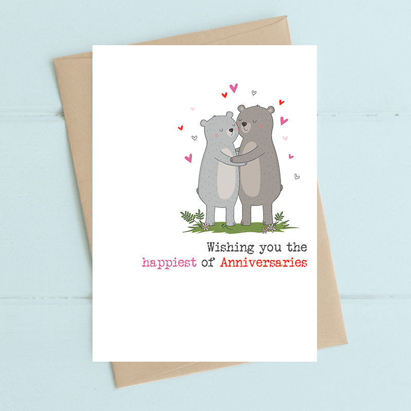 Anniversary card featuring two illustrated bears in a warm embrace surrounded by floating hearts with the sentiment Wishing you the happiest of Anniversaries